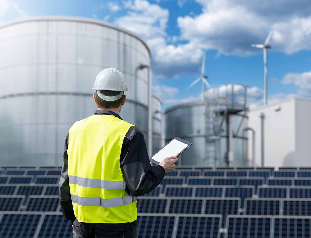 Engineer with tablet computer on a background of Green Hydrogen factory