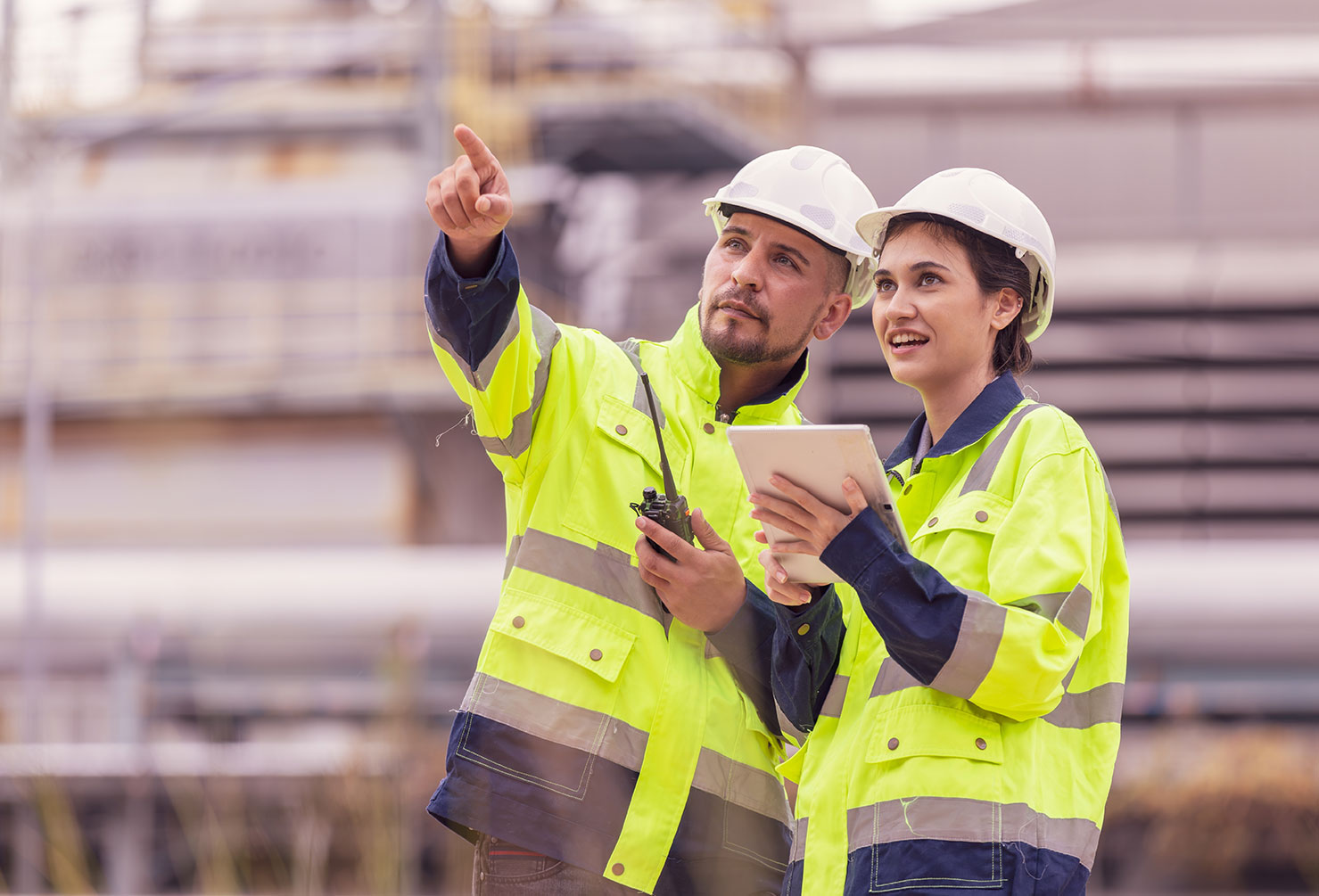 Male and female engineer in front of a oil and gas refinery