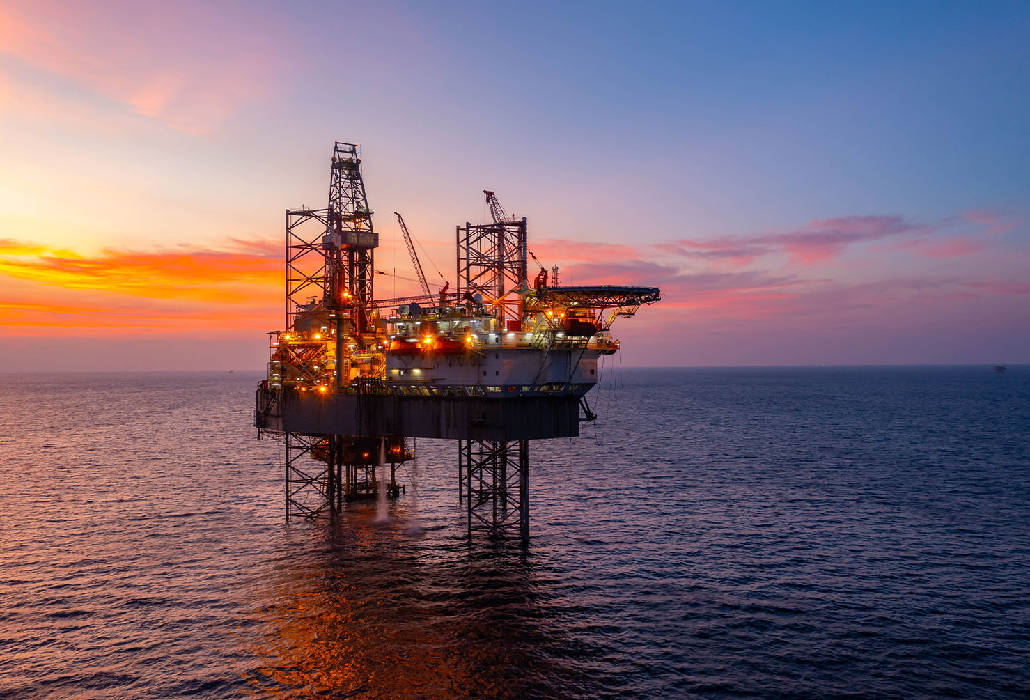 Aerial view of silhouette offshore jack up drilling rig during sunset