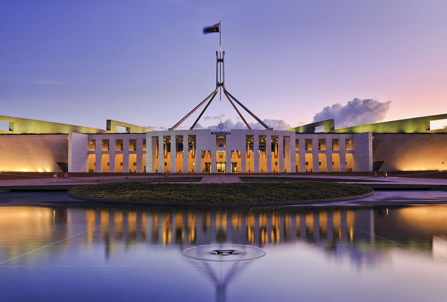 Australia Parliament House at sunset from a view across the water.