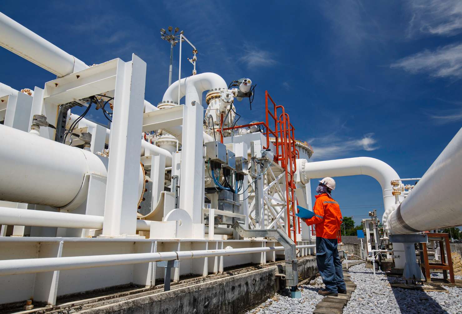 Enxgy-Blog-Staying-In-Oil-Gas-Career Male worker inspection at steel long pipes and pipe elbow in station oil factory during refinery valve of visual check record pipeline oil and gas industry