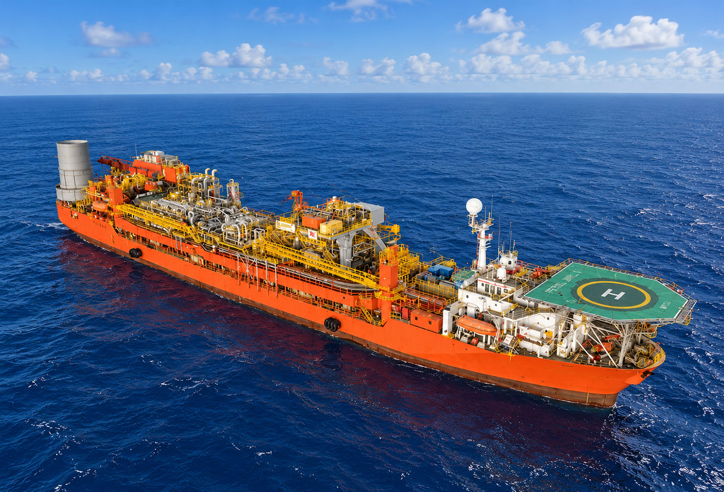 Aerial view of an FPSO vessel moored in the tropical blue-green waters of the Timor Sea under hazy light